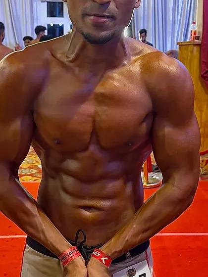 A client practicing his front lat spread on stage. This pose is crucial for showing width and a tapered waist.