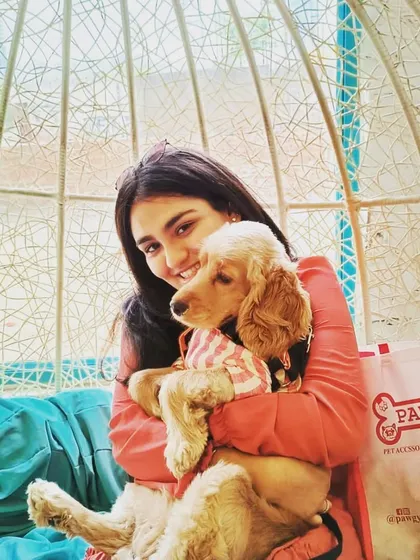 Dog hair is my go-to accessory. A guest enjoying a cuddle with a cute cocker spaniel puppy in our swing chair.