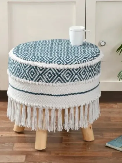 A blue and white patterned boho stool with a clean, geometric design and fringe details. It's perfect for adding a touch of color to a living room or bedroom.