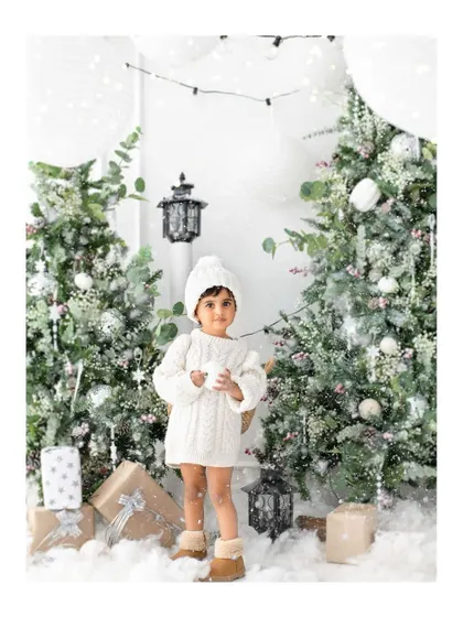 A winter wonderland scene in my studio. This little one looks so sweet in her cozy white sweater, surrounded by snowy trees and soft light for her holiday portrait.