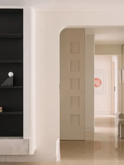 We used large sliding panels to demarcate private and open spaces, enhancing the home's utilitarian nature. This view through an arched doorway shows the dignified layering of materials and tonal consistency.