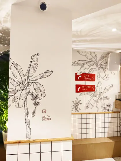 A wider view of the hand drawn murals at Smoke House Deli, showing how the art flows across different walls and pillars to create an immersive environment.