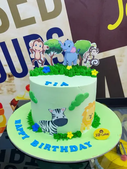A 3kg jungle cake with light green frosting and cute animal cutouts.