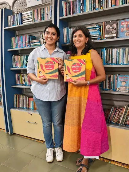 The author and illustrator duo pose for a photo in front of our library shelves.
