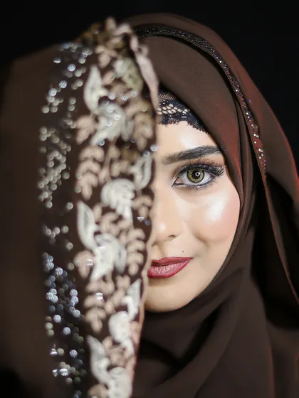 A creative shot using the hijab to frame the face, drawing attention to the expertly applied eye makeup.