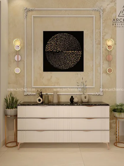 A stylish console table setup with a large piece of abstract art, ornate wall moulding, and modern circular wall lights.