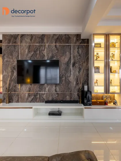 This entertainment center combines a dark marble-finish wall with a clean white console. The adjoining glass display cabinet with internal lighting is perfect for showcasing treasured collectibles.