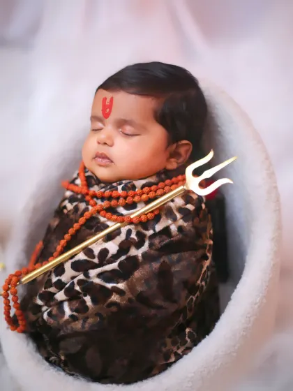 A detailed close-up from another 'Little Shiva' session, showing the textures of the swaddle and the rudraksha beads.