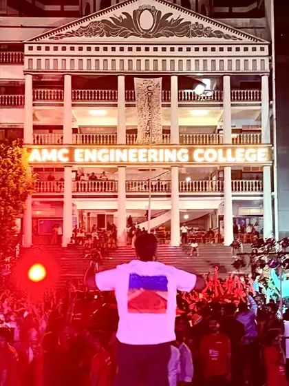A wide shot from my perspective on stage at AMC Engineering College. Seeing a sea of students with their hands up, completely lost in the music, is an incredible sight.