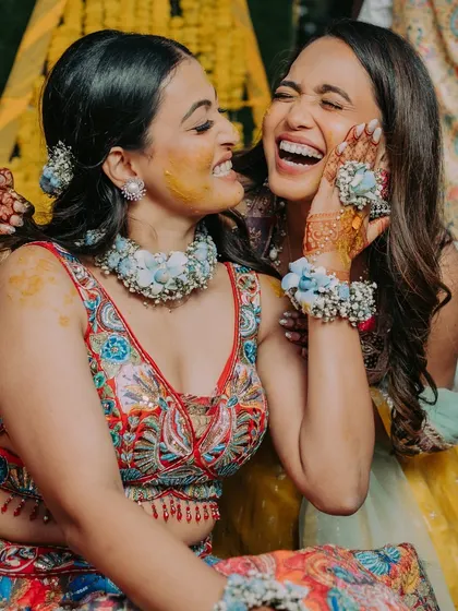A candid moment of pure joy between the bride and her friend during the Haldi ceremony.