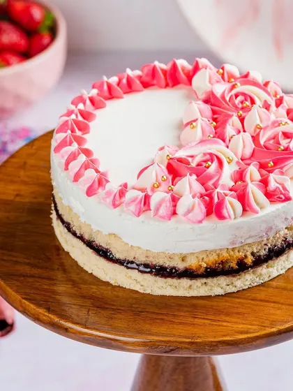 Our Pink Paradise cake is a true showstopper. With layers of vanilla sponge, cream cheese, and oozing berries, it's a melt-in-your-mouth experience decorated with beautiful pink and white frosting.