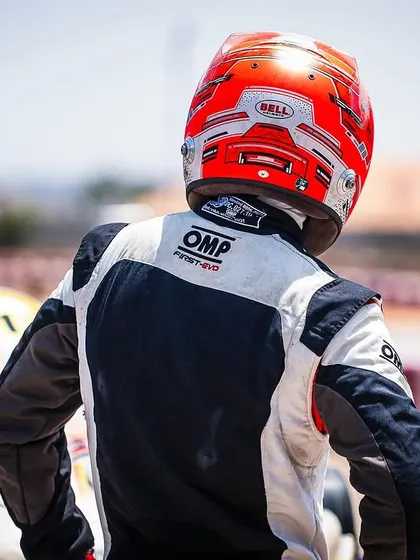 A driver looks on from the grid, waiting for the race to start. This shot captures the focus and anticipation of a competitor.