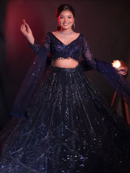 A full, joyous shot of the blue sequined lehenga. The smile says it all, this is an outfit made for celebrating.