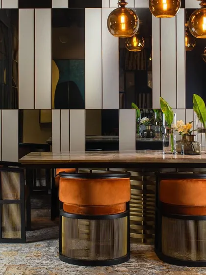 For this dining room wall, I created a high-contrast panel design using alternating strips of leather, mirror, and metal. This mixed-media approach adds a layer of visual interest and luxurious texture.