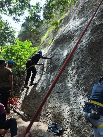 Participants learn top-rope climbing techniques under the shade of trees at our Ramanagara base.