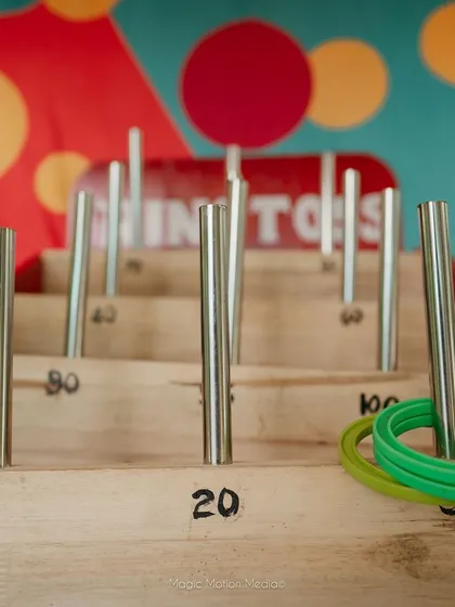 A ring toss game stall set up for guest entertainment. Carnival-style games are a fantastic way to keep guests of all ages engaged and entertained during the event.