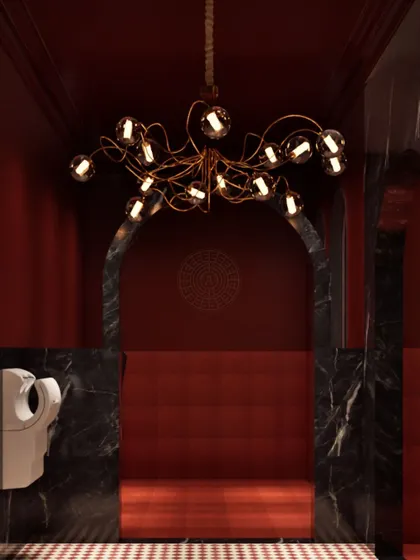The entrance to the ladies' washroom at Koko, featuring a black marble archway and a modern glass-sphere chandelier that contrasts beautifully with the rich red interior.