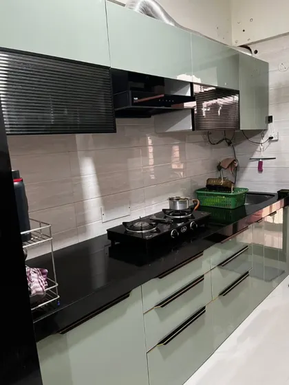Another angle of the mint-green kitchen, highlighting the glossy finish and the efficient use of space in this parallel layout.