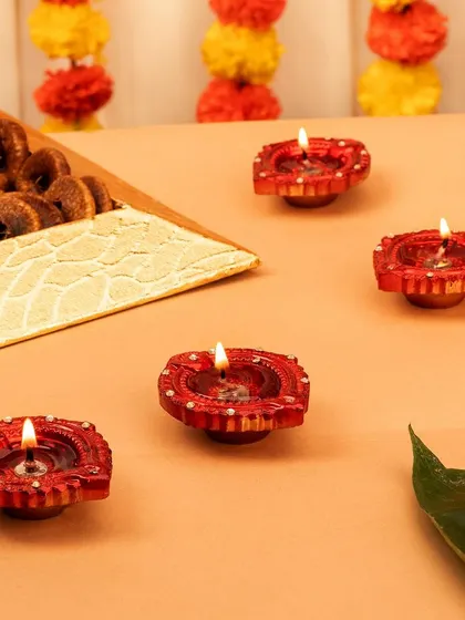 A set of traditional red terracotta diyas. This simple, elegant shot captures the essence of Diwali lighting.