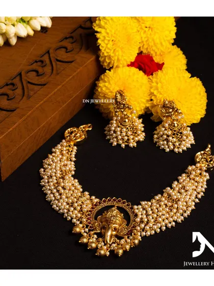 This Ganesha-themed choker with pearl clusters is a unique and auspicious piece. It's perfect for a festive occasion or a wedding.