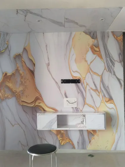 A custom wallpaper that mimics the look of white and gold marble. This design covers the entire TV wall and ceiling portion for a luxurious, continuous look.