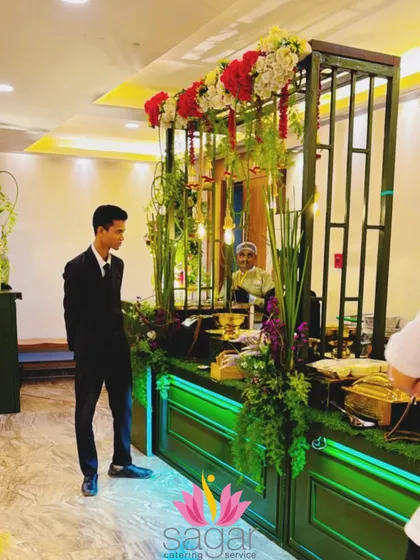 A guest admires the intricate details of the green and gold food station. The setup is designed to be interactive and visually engaging from all angles.