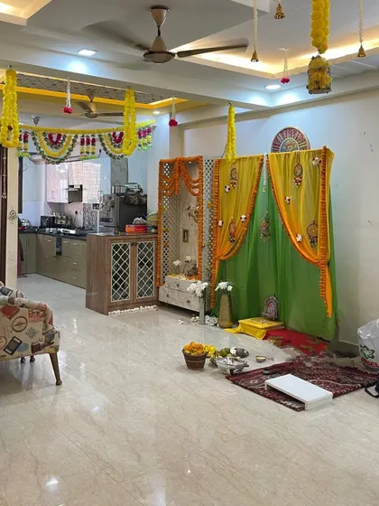 This is how I integrate a festive pooja or ceremony area into the living room. The yellow and green drapes and marigold garlands make the whole house feel connected and celebratory.