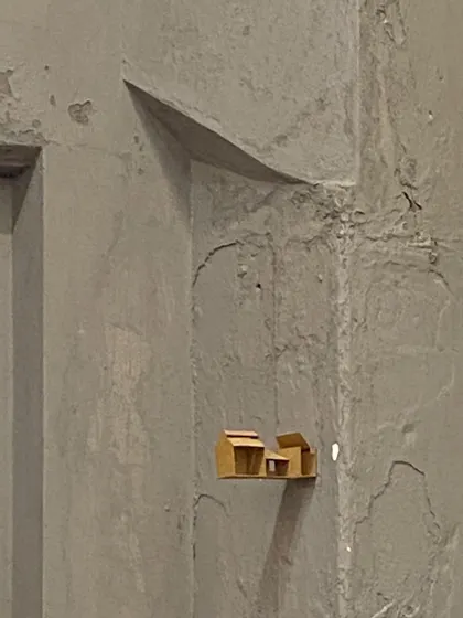 A tiny architectural model placed in a niche in the wall, a playful intervention.