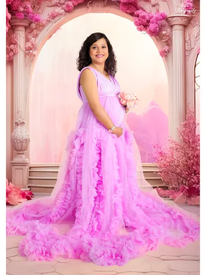 A full-length view of one of our beautiful ruffled lavender gowns. The long train spreads out, creating a dramatic and fairytale-like effect in this studio shot.