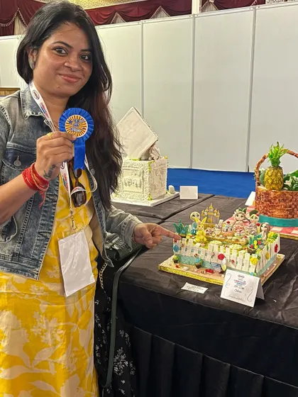 Pointing to my creation at the competition table. I was so excited to present this cake, which brought together so many different characters in one magical scene.