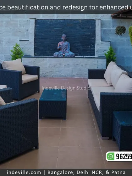 This terrace lounge area is designed for ultimate calm. It features a comfortable wicker sofa set facing a serene Buddha statue set against a dark stone water feature, creating a perfect zen-like ambiance.