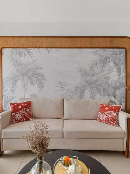 A full view of the living and dining area, showing the seamless flow from the entryway with its Saura art to the main seating area. The design feels connected and intentional.
