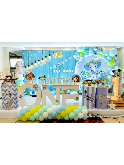 A baby elephant theme with a large 'ONE' sign and photo frames of the birthday boy.
