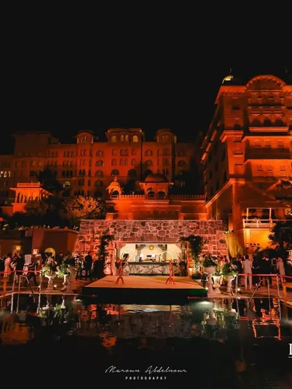 A stunning view of the welcome dinner setup over a pool. The reflection of the lights on the water, combined with the regal architecture, created a truly breathtaking scene.
