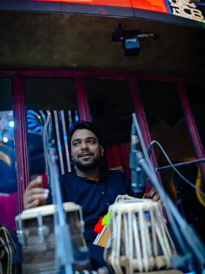 Our tabla player with a smile, enjoying the music. His intricate rhythms add an essential layer of tradition and energy to our sound.