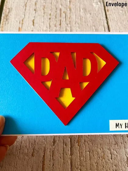 For the superhero dad, we created this "Super Dad" card. The design features the iconic Superman-style logo with the word "DAD" cut out, making it a fun and powerful message.
