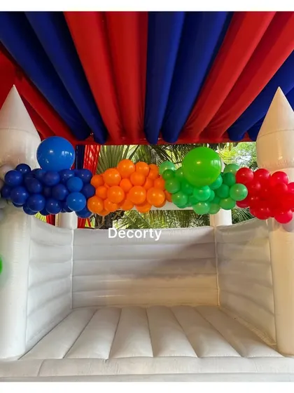 No superhero party is complete without a bouncy castle! This white bouncy castle is decorated with colorful balloons, ready for kids to jump and play.