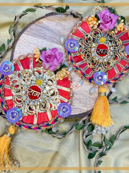 This red "Ram Ram" design features intricate golden filigree work and yellow tassels, creating a rich and festive look.