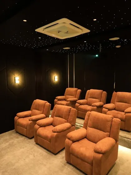 A full view of the seating area, showing the spacious layout and the elegant, dark design punctuated by warm, ambient lighting.