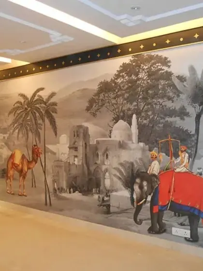 This large-scale mural depicts a vintage Indian procession with elephants and camels in a monochrome palette with color accents. It creates a powerful historical narrative along this long hallway, turning it into a gallery wall.