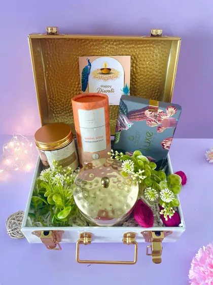 This premium metal trunk hamper is curated with a gold-lidded jar, a luxury chocolate box, and other high-end items for a sophisticated gift.