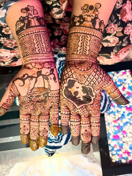 A creative baby shower mehendi featuring a cradle on one palm and a mother-and-child silhouette on the other. These personalized story-telling designs are what make seemantha mehendi so special.
