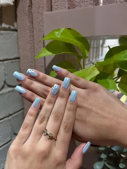 Simple, sweet, and chic. A lovely powder blue manicure with a delicate, hand-painted daisy accent nail.