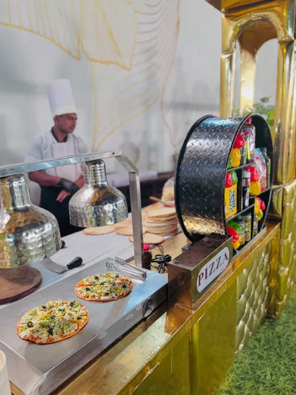 A chef at the pizza station, with freshly baked pizzas ready on the counter. We ensure a constant supply of hot, delicious pizza throughout the event.