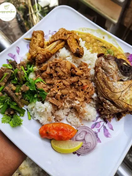 This thali highlights some unique Manipuri ingredients. It includes banana flower eromba, baby bamboo singju, fried chicken wings, and a whole fried fish head.