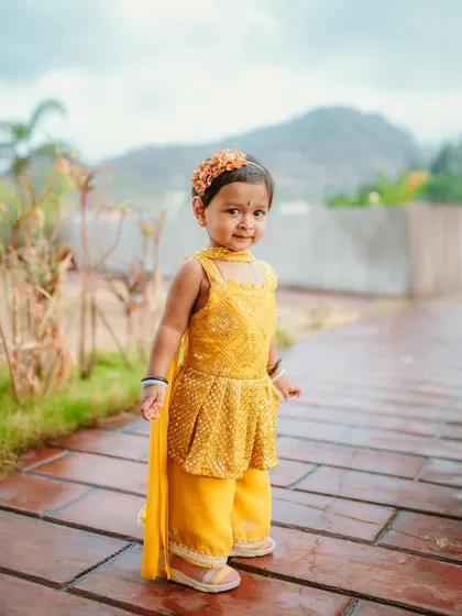 A cute portrait of a young guest dressed in yellow for a Haldi ceremony. I make sure to capture the entire atmosphere, including the little guests.