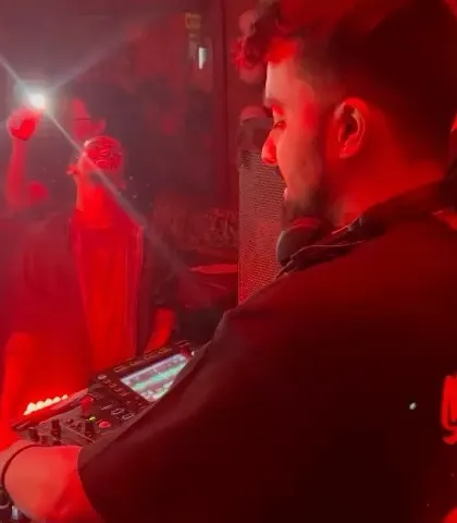 A close-up of me in a red-lit booth, lost in the music. For me, music is a form of therapy, and I love sharing that feeling.