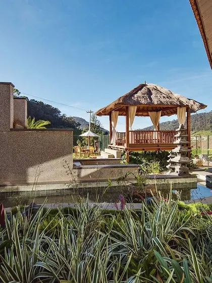 Another perspective of the gazebo and pond at Finch Ecofarms, highlighting the use of local stone and tropical plants. Every element is chosen to create a cohesive, nature-inspired holiday experience.