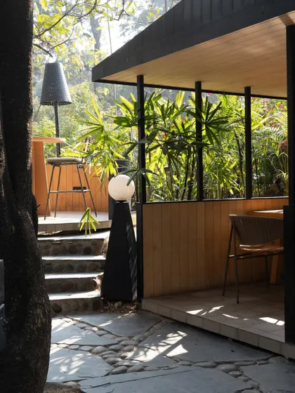 A pathway at Tubu, showing how the dining pods are carefully placed to minimize impact on the existing trees and topography. The design is a conscious adaptation to the natural environment.