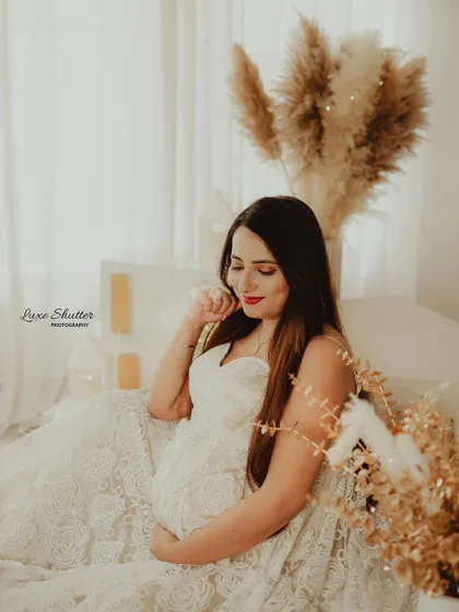 A quiet, dreamy moment in our boho studio setup. The intricate white lace gown and warm, sparkling lights create a cozy and romantic atmosphere.